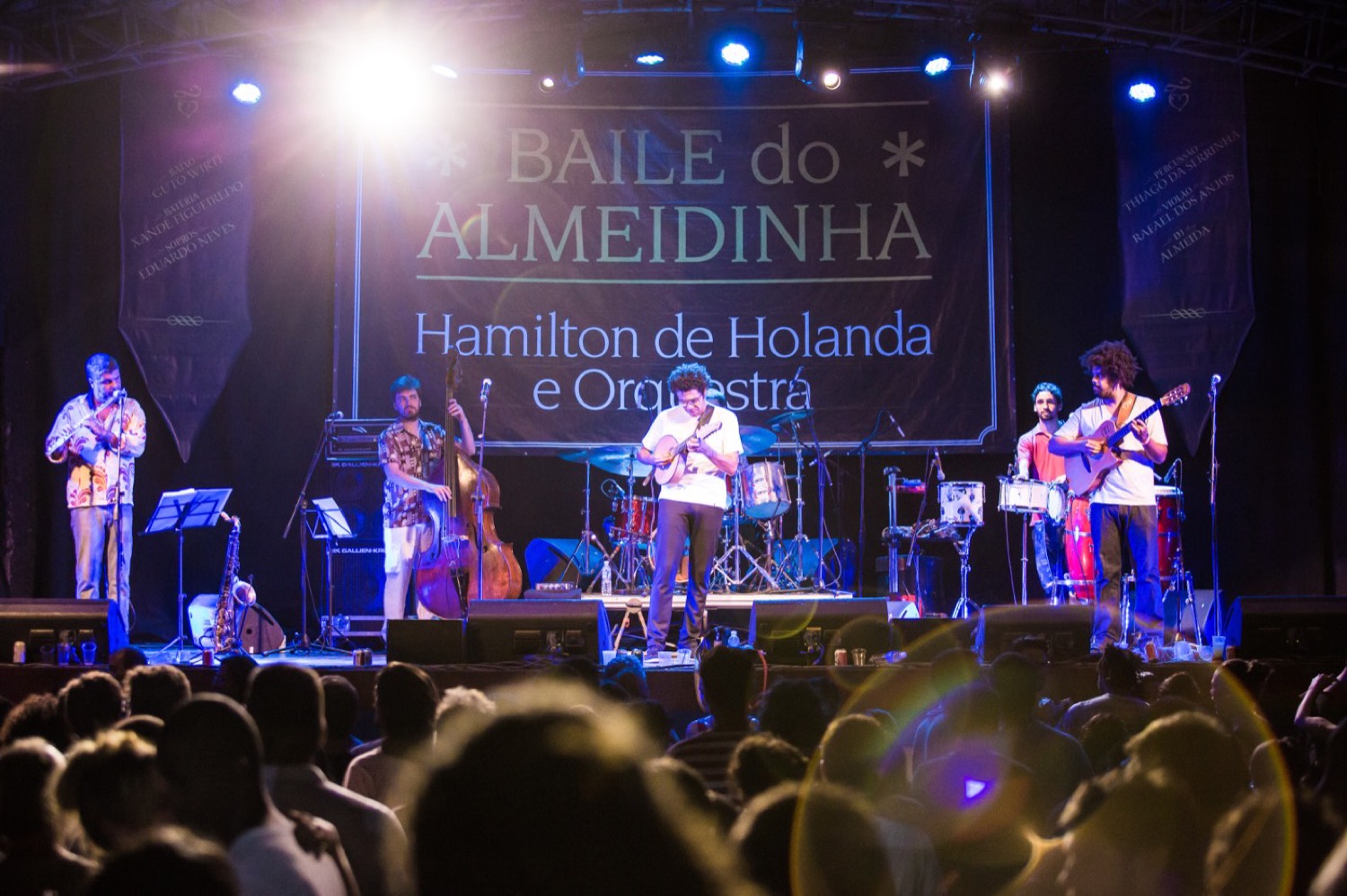 Palco do Circo Voador com a faixa Baile do Almeidinha, Hamilton de Holanda e orquestra tocando para o público